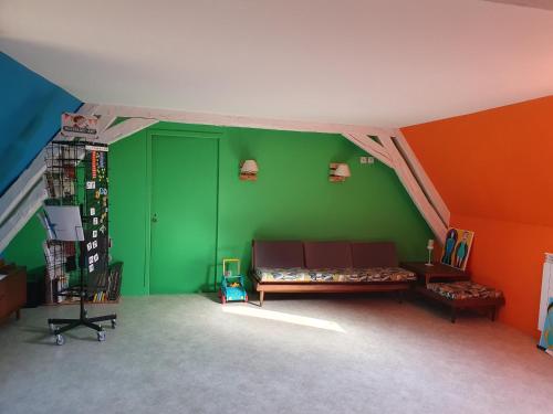 ein Wohnzimmer mit einem Sofa in einer grünen Wand in der Unterkunft La ferme du Riau in Aurouer