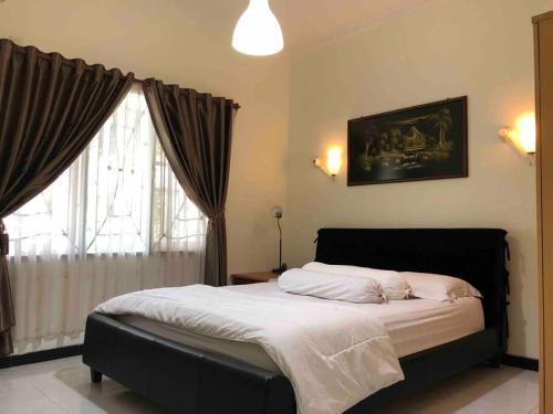 - une chambre avec un grand lit et une fenêtre dans l'établissement Mitra@Guesthouse b29, à Batam Center
