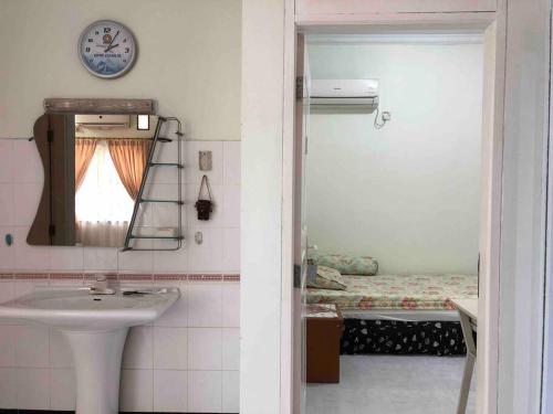 La salle de bains est pourvue d'un lavabo, d'un miroir et d'un lit. dans l'établissement Mitra@Guesthouse b29, à Batam Center