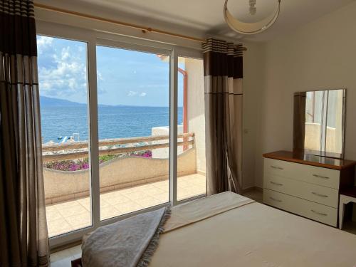 ein Schlafzimmer mit Bett und Blick auf das Meer in der Unterkunft Apartments Wonderful bay in Sarandë