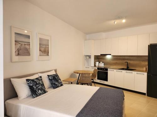 een slaapkamer met een groot bed en een keuken bij ELISOS Studio Apartment with swimming pool in Vlorë