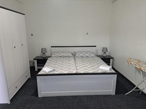 - une chambre avec un lit, 2 tables et 2 lampes dans l'établissement Apartman Ivo, à Livno