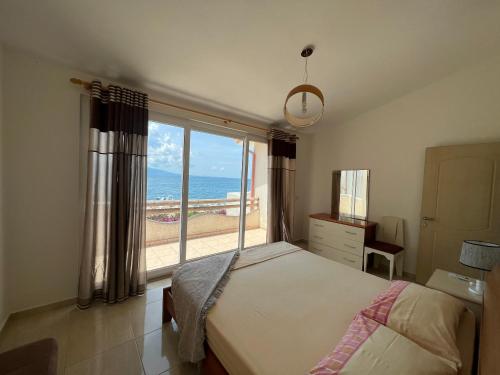 1 dormitorio con cama y vistas al océano en Apartments Wonderful bay, en Sarandë