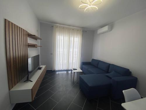 un salon avec un canapé bleu et une télévision dans l'établissement A&T Apartments, à Durrës