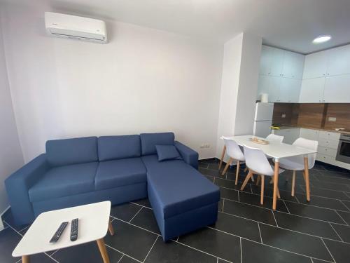 - un salon avec un canapé bleu et une table dans l'établissement A&T Apartments, à Durrës