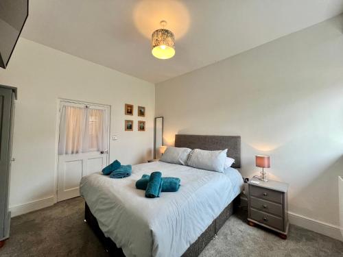 a bedroom with a large bed with blue pillows at The Snug at Ascerton in Sidmouth