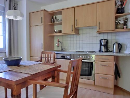 una cucina con un tavolo di legno e un tavolo e sedie di Ferienwohnung H 25 "Tausendschön" a Graal-Müritz