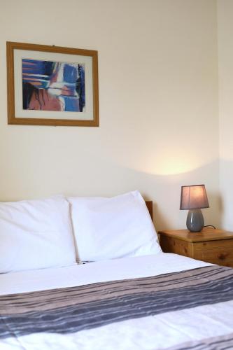a bedroom with a bed and a lamp on a night stand at Long Quay Apartments, Clonakilty in Clonakilty