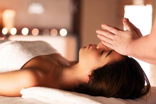 a woman laying on a bed with her hands on her face at Roxon Urban Ramat Gan in Ramat Gan