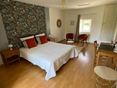 1 dormitorio con 1 cama blanca grande con almohadas rojas en Chambres d'Hôtes Les laitières en Beaurepaire