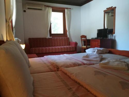 um quarto com 2 camas, um sofá e uma janela em комплекс Щастливците em Starozagorski Bani