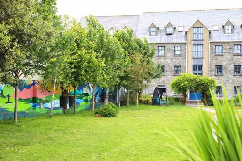 a building with a mural in front of a yard at Long Quay Apartments, Clonakilty in Clonakilty
