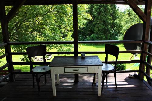 einen Tisch und zwei Stühle auf einer Veranda in der Unterkunft U Lesíčka in Vysoká