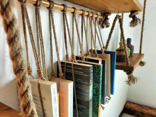een bos boeken hangend op een plank bij Solstice in Santa Maria