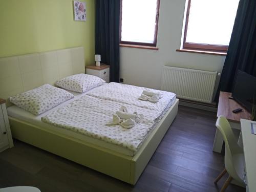 een slaapkamer met een bed met twee handdoeken erop bij Waldhof in Jiříkov