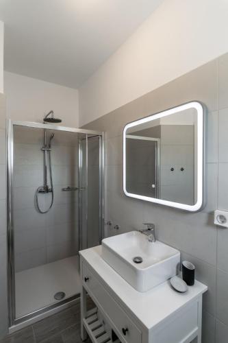 a bathroom with a sink and a shower and a mirror at Sunset Village 2 in Paleochori