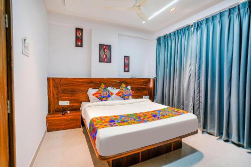 a bedroom with a bed and blue curtains at Via Crystal Inn in Pune