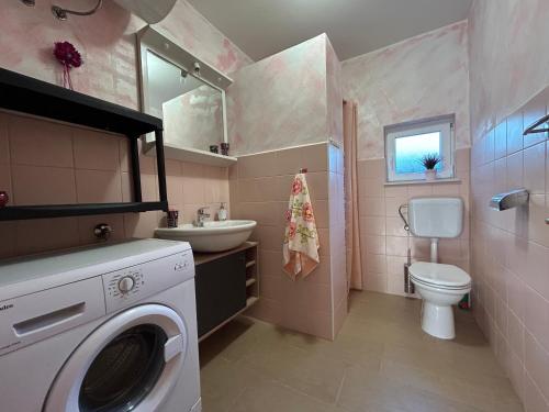 een badkamer met een wasmachine en een wastafel bij Dora house with WiFi and outdoor swimming pool in Pula