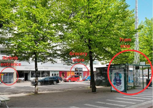 a tree in front of a bus stop with red circles at Stylish Nordic Studio by Tram Stop in Helsinki