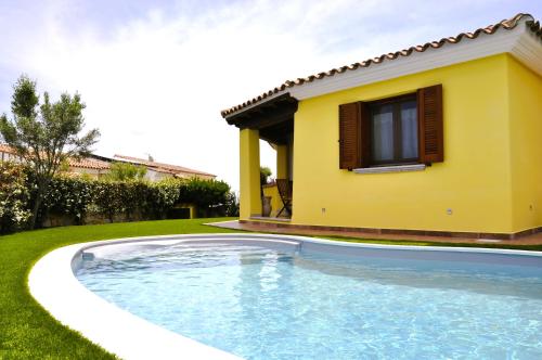 a swimming pool in front of a house at Villa Nadia con piscina privata Budoni in Tanaunella