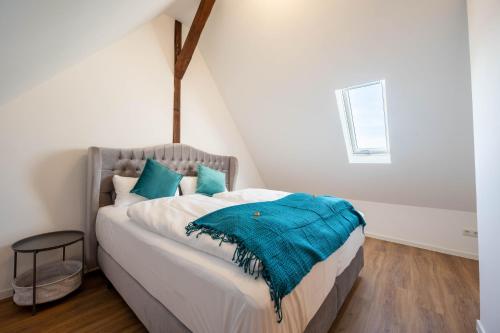 ein Schlafzimmer mit einem Bett mit einer blauen Decke darauf in der Unterkunft Lit Living - Luxury - Box Spring - Parking - 4 Bed Rooms - 13 persons - Duplex apartment in Hemsbach