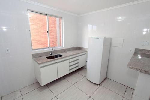 La cuisine blanche est équipée d'un évier et d'un réfrigérateur. dans l'établissement DiRoma Resort / Splash e Acqua Park, à Caldas Novas
