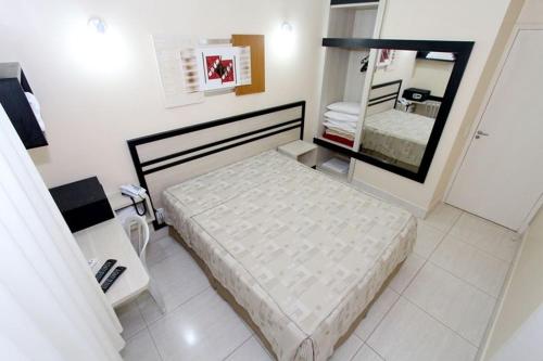 - une petite chambre avec un lit et un miroir dans l'établissement DiRoma Resort / Splash e Acqua Park, à Caldas Novas