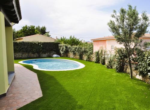 a backyard with a swimming pool and green grass at Villa Nadia in Tanaunella