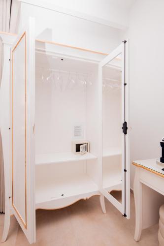 a white cabinet with a mirror in a room at Giorgio Boutique Hotel in Sliema