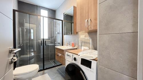 uma casa de banho com um WC e uma máquina de lavar roupa em Homie Suites - Newly-constructed Apartment Complex in Beşiktaş em Istambul