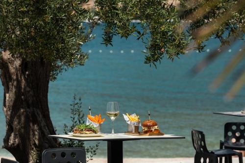 a table with two plates of food and a glass of wine at Marinus Beach Hotel in Marina