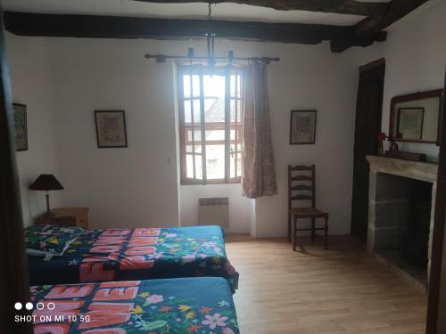 um quarto com 2 camas e uma janela em Les colombages bis em Pazayac