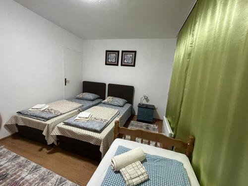 - une chambre avec 2 lits et 2 chaises dans l'établissement Apartman Reyan, à Jajce