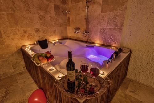 內夫謝希爾的住宿－CaveAdocia，浴缸配有葡萄酒杯和葡萄酒瓶