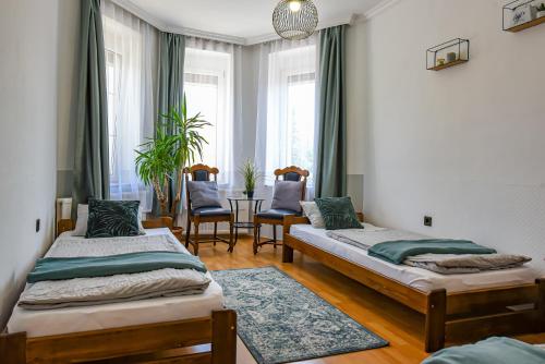 2 camas en una habitación con mesa y sillas en Hajdúhegy Vendégház, en Eger