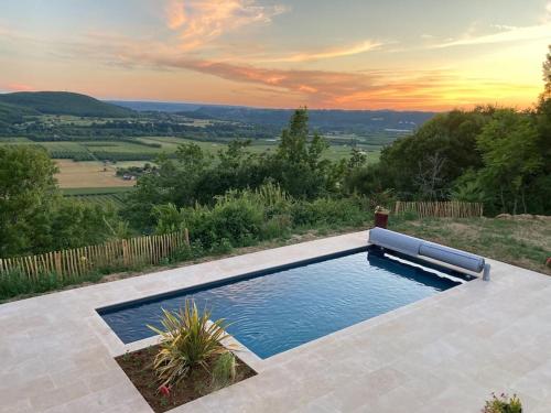 une piscine avec un coucher de soleil en arrière-plan dans l'établissement Villa avec vue exceptionnelle sur la Vallée, à Castels