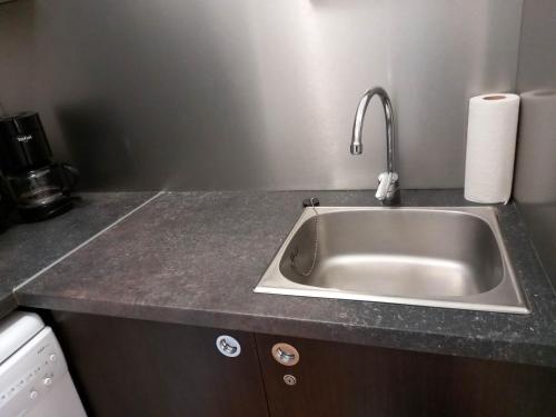 un comptoir de cuisine avec un évier en argent dans l'établissement Joli T2 Climatisé proche plage dans résidence Vacance, à La Londe-les-Maures