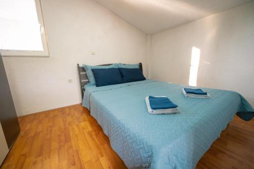 um quarto com uma cama azul com toalhas em Villa Bezho Ljubanista em Ljubaništa