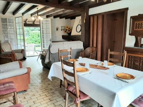 une salle à manger avec une table et des chaises blanches dans l'établissement Maison spacieuse avec jardin, proche commerces et plage, 6 couchages, parking privatif - FR-1-239-902, à Capbreton