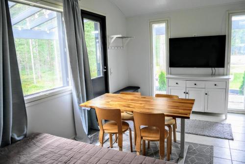 uma sala de jantar com uma mesa de madeira e cadeiras em Cozy 4 person guesthouse on quiet residential area em Oulu