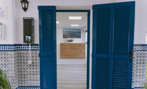 una puerta azul que conduce a un baño con lavabo en C Veneziola A5J, en La Manga del Mar Menor