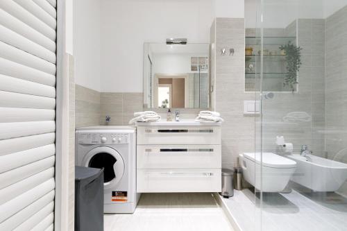 a bathroom with a washing machine and a sink and a toilet at beautiful 3 room-flat near palais in Cannes