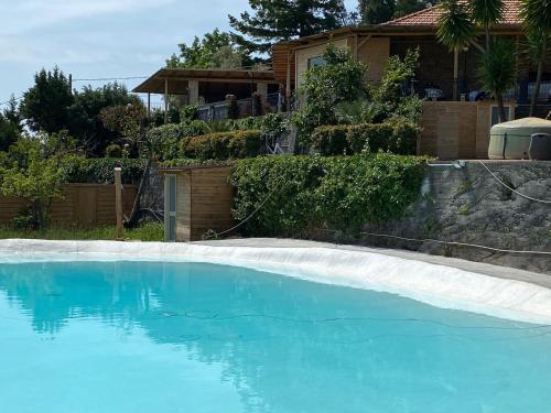 einen Pool mit blauem Wasser vor einem Haus in der Unterkunft B&B Belvedere in Presa