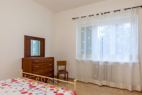 ein Schlafzimmer mit einem Bett, einer Kommode und einem Fenster in der Unterkunft Casa Bruna in Seravezza