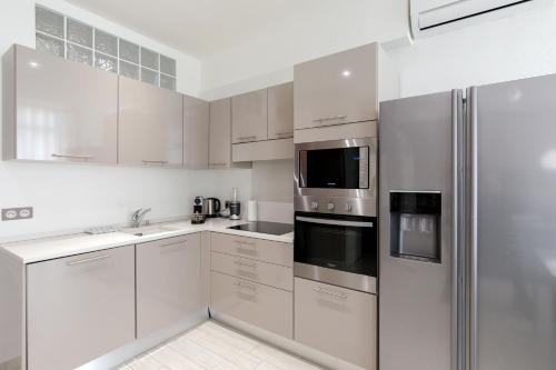 a kitchen with white cabinets and stainless steel appliances at beautiful 3 room-flat near palais in Cannes