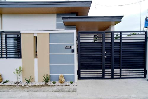 a house with a black garage door and some plants at Bali-inspired Villa with Dipping Pool by Pallet Homes in Iloilo City