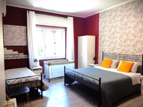 1 dormitorio con 2 camas, ventana y escritorio en Chloe's Rooms en Cagliari