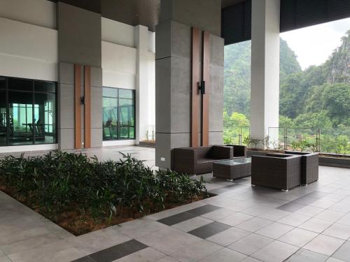 a lobby with couches and plants in a building at Onsen Oasis Premium Suites in Tambun
