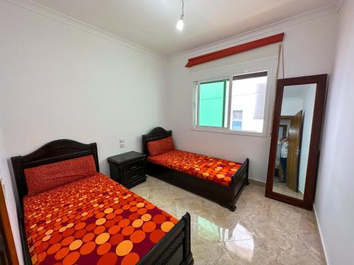 um quarto com 2 camas e um espelho em Grand appartement en face à la mer avec piscine. em Oued Laou
