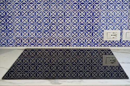 a blue and white tile wall with two electrical sockets at Lo Scoglio della Formica B&B in Capo dʼOrlando
